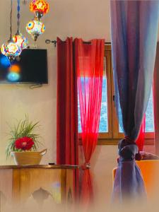 een kamer met rode gordijnen, een tafel en een raam bij Casas cueva El Castaño in Pampaneira