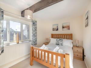 a bedroom with a bed and a window at The Old Barn in Weybourne