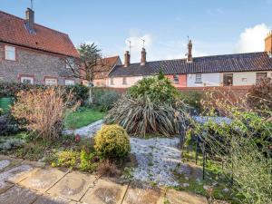 a garden in front of a house at The Old Barn in Weybourne