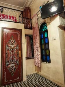 Habitación con puerta marrón y ventana en Dar Atlantic en Fez