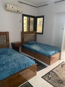 a bedroom with two beds and a window at A lovely apartment for rent in Cairo