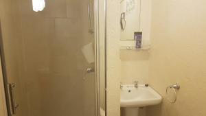 a bathroom with a shower and a toilet and a sink at The Brema Hotel in Blackpool
