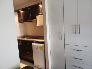 a kitchen with white cabinets and a small refrigerator at Suite de lujo en excelente sector, netflix, disney plus in Quito