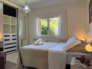 Un dormitorio con una cama grande y una ventana en Apartamentos Residencial Vale Enotria by Achei Gramado, en Gramado