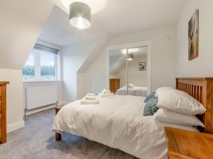 una camera da letto con un grande letto bianco e uno specchio di Iora Rua-uk40006 a Gartmore
