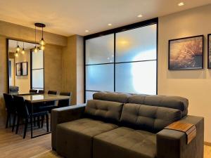 sala de estar con sofá y comedor en Apartamentos Vita Boulevard CENTRO by Achei Gramado, en Gramado