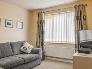 a living room with a couch and a window at Pine View in Mynyddislwyn