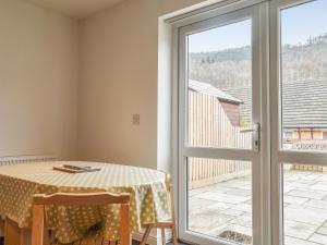 een eetkamer met een tafel en een glazen schuifdeur bij Pine View in Mynyddislwyn