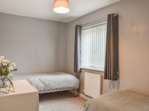 1 dormitorio con 2 camas y ventana en Pine View, en Mynyddislwyn