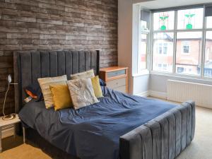 ein Bett mit blauer Bettwäsche und Kissen in einem Schlafzimmer in der Unterkunft Two The Manor Born in Tynemouth