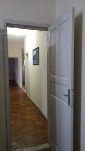 a hallway with a white door and a hallway with a wooden floor at Pousada Família Guarapari in Guarapari