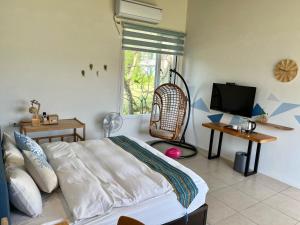 a bedroom with a bed and a flat screen tv at Mei Jung B&B in Zhixue