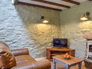 ein Wohnzimmer mit einem Sofa und einem Tisch mit einem TV in der Unterkunft Little Sitch Barn - Uk39602 in Matlock Bank