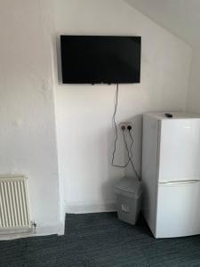 un televisor colgado en una pared junto a una nevera en Africana restaurant and bar, en Burslem