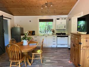 a kitchen with a wooden table and a wooden ceiling at Barefoot Villas and Retreat in Christina