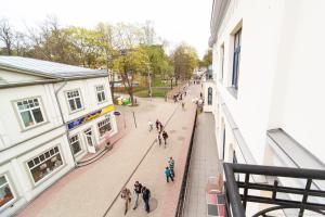 a group of people walking down a street next to a building at Apartamenti Alto & Ko in Jūrmala