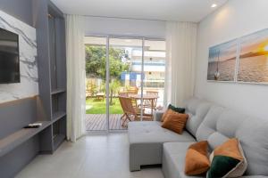 sala de estar con sofá y mesa en Caraíbas 01 - Excelente apartamento garden 2 suítes - À poucos metros da praia, en Bombinhas