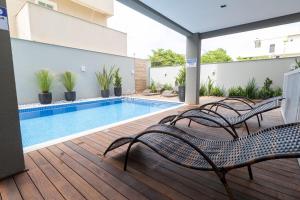 una terraza con sillas y una piscina en Caraíbas 01 - Excelente apartamento garden 2 suítes - À poucos metros da praia, en Bombinhas