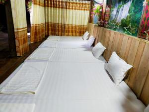 a room with four beds with white sheets and pillows at Homestay Tuấn Nghĩa - Hang Phượng Hoàng - Võ Nhai in Hoan Chung