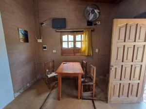 a room with a wooden table and chairs and a window at La Mungana in Cafayate