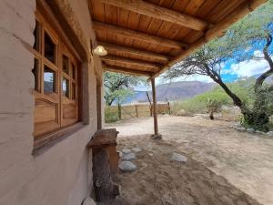 a porch of a house with a wooden roof at La Mungana in Cafayate