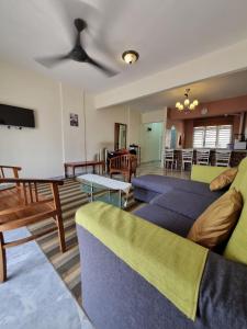 uma sala de estar com dois sofás e uma televisão em Homestay α Cocobay Condo Resort em Porto Dickson