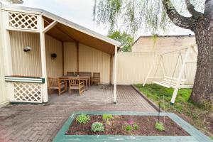 a patio with a table and a tree at Apartamenti Alto & Ko in Jūrmala