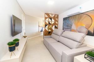 sala de estar con sofá y TV en Puntarenas 202 - Excelente apartamento 2 suítes - Finamente mobiliado e decorado - À poucos metros da praia, en Bombinhas