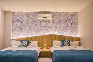 礁溪鄉的住宿－艾玹爾溫泉會館，酒店客房带两张床和一面墙