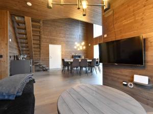 een woonkamer met een tafel en een televisie aan de muur bij 12 person holiday home in IDRE in Idre