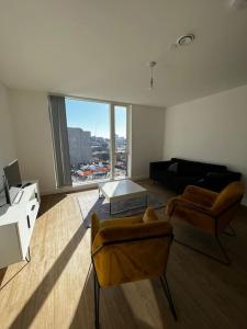 a living room with two chairs and a table at Stylish 2 bedroom apartment Manchester City centre in Manchester
