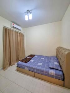 um quarto com uma cama e um sofá em Homestay α Cocobay Condo Resort em Porto Dickson