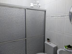 a bathroom with a shower and a toilet and a sink at Hotel Goytacá in Paragominas