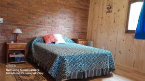 a bedroom with a bed and a brick wall at Casa de la Oma in Ruiz de Montoya