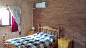 um quarto com uma parede de tijolos e uma cama em Casa de la Oma em Ruiz de Montoya