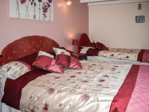 een slaapkamer met een bed met een rood hoofdeinde bij Anneth Lowen in Perranwell
