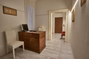 einen Flur mit einem Schreibtisch mit einem TV und einem Stuhl in der Unterkunft Cuore di Bologna Suites in Bologna
