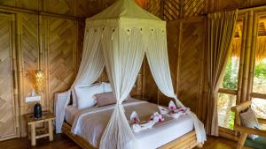 a bedroom with a bed with a canopy at Elang Hillside Bamboo Villas in Labuan Bajo