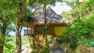 a tree house with a thatched roof at Elang Hillside Bamboo Villas in Labuan Bajo