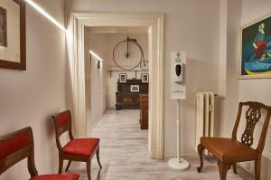 un pasillo con sillas y una mesa en una habitación en Cuore di Bologna Suites, en Bolonia