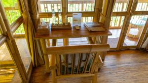 a small wooden table in a room with windows at Elang Hillside Bamboo Villas in Labuan Bajo