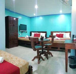 um quarto com uma mesa e uma cama e uma televisão em Bora Sky Hotel em Boracay