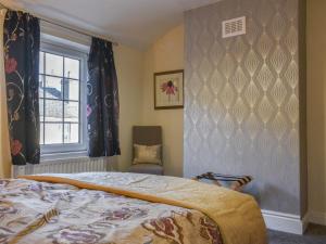 a bedroom with a bed and a window and a chair at Sea Breeze in Mossbay