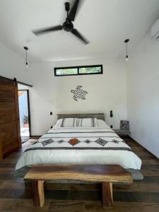 een slaapkamer met een bed en een plafondventilator bij Hostel Flakos in Zihuatanejo