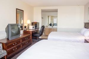 ein Hotelzimmer mit zwei Betten und einem Fernseher in der Unterkunft Hawk's Nest Lodge in Osage Beach + 6 Fotos