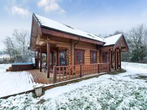 a log cabin in the snow with a deck at Ty Ceirios - Uk42100 in Carno