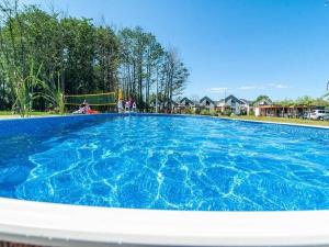 a large pool with blue water in a yard at Comfortable, air-conditioned holiday houses, pool, sauna, Niechorze in Niechorze