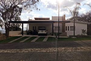 a house with a car parked in front of it at Casa Aguila Gran Reserva in Ixtapan de la Sal