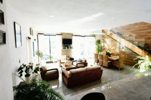 uma sala de estar com sofás e uma mesa e algumas plantas em Casa Aguila Gran Reserva em Ixtapan de la Sal