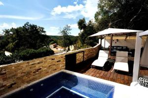 une piscine avec deux chaises et un parasol dans l'établissement Casa Aguila Gran Reserva, à Ixtapan de la Sal